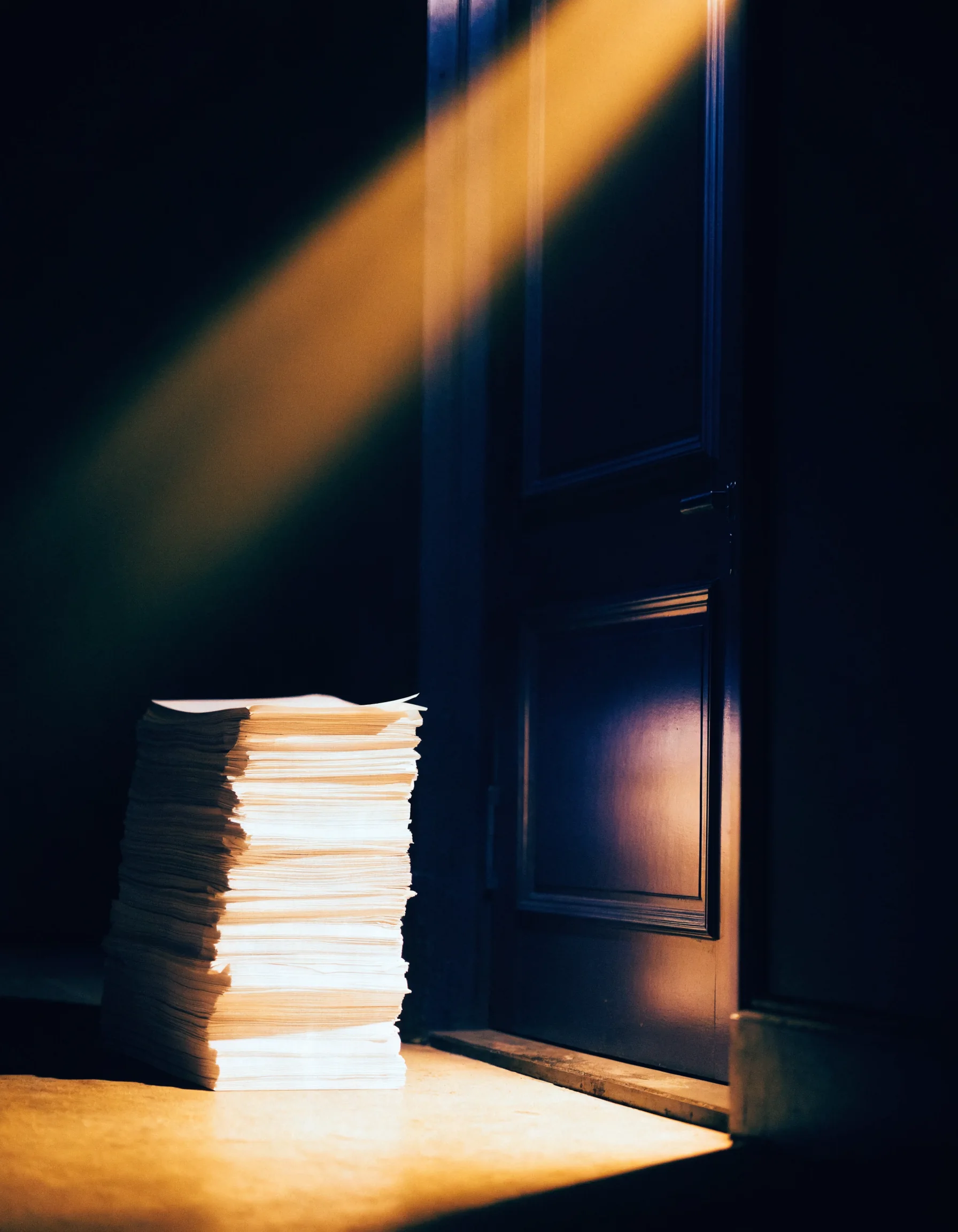 A stack of paper beside a closed restaurant door at night